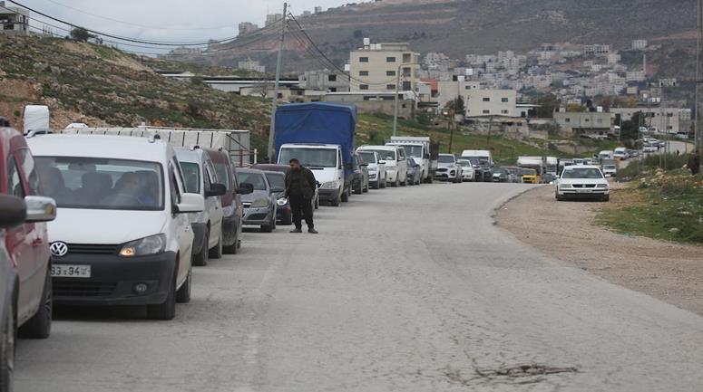 مواطنون ينتظرون عند حاجز عسكري إسرائيلي قرب نابلس بعد أن أغلقت قوات الاحتلال الاسرئيلي الحواجز والبوابات الحديدية عند مداخل المدن في الضفة الغربية والقدس المحتلة.